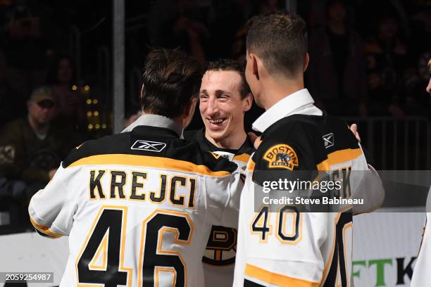 David Krejci and Brad Marchand of the Boston Bruins hug during in a pregame "Return of a Champion Era Night" ceremony before the game against the...