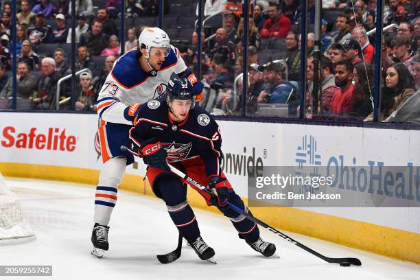 Yegor Chinakhov of the Columbus Blue Jackets battles to keep the puck from Vincent Desharnais of the Edmonton Oilers during the first period of a...