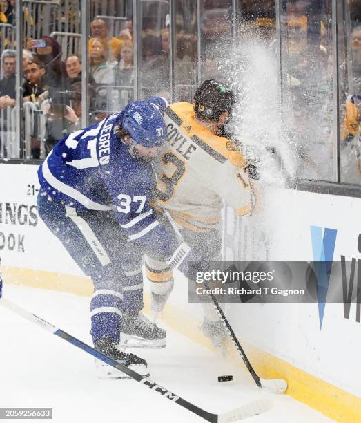 Timothy Liljegren of the Toronto Maple Leafs checks Charlie Coyle of the Boston Bruins during the first period at the TD Garden on March 7, 2024 in...