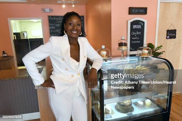 Owner Renel Turner stands next to a cake case during a grand opening of Nelly's Treats, a new bakery that offers treats for dogs and humans alike on...