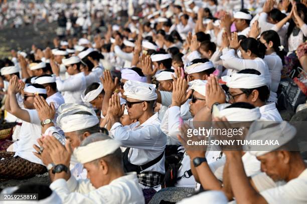 Balinese people pray during the Melasti ceremony prayer at a beach in Denpasar, on Indonesia's resort island of Bali on March 8, 2024. Indonesia's...