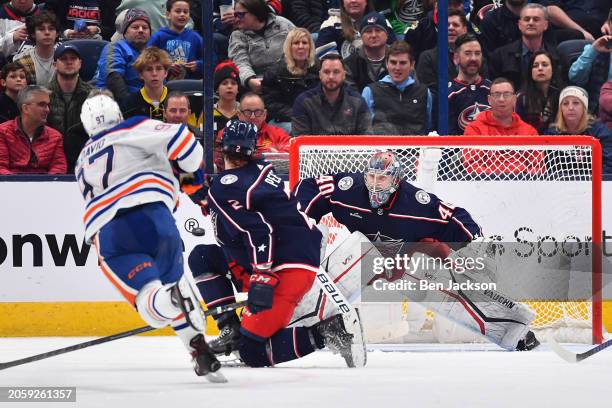 Goaltender Daniil Tarasov of the Columbus Blue Jackets defends the net as Connor McDavid of the Edmonton Oilers shoots the puck during the third...