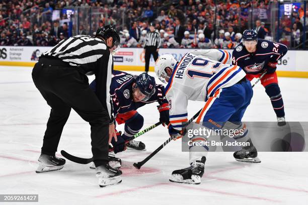 Justin Danforth of the Columbus Blue Jackets and Adam Henrique of the Edmonton Oilers battle for the puck in a face-off during the third period of a...