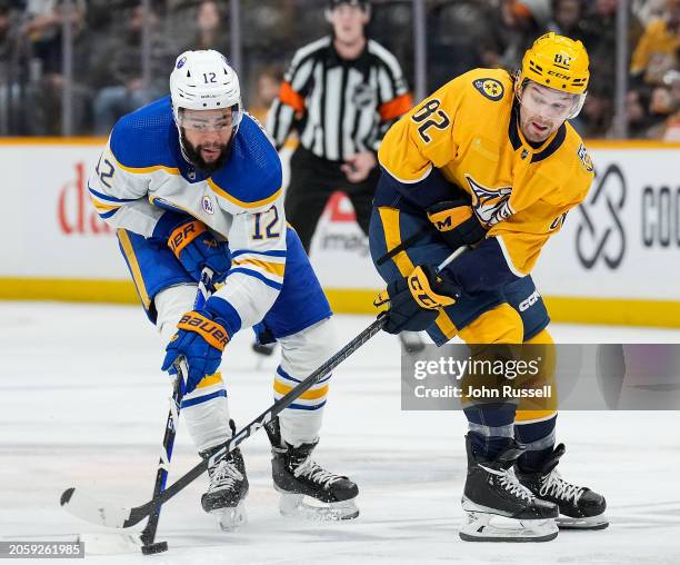 Jordan Greenway of the Buffalo Sabres battles for the puck against Tommy Novak of the Nashville Predators during an NHL game at Bridgestone Arena on...