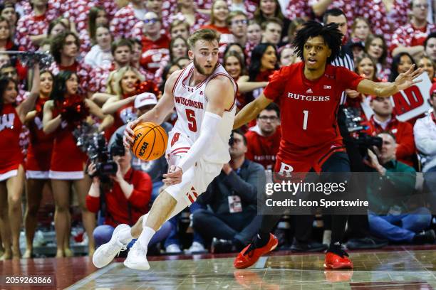 Wisconsin forward Tyler Wahl dribbles past Rutgers guard Jamichael Davis during a college basketball game between the University of Wisconsin Badgers...