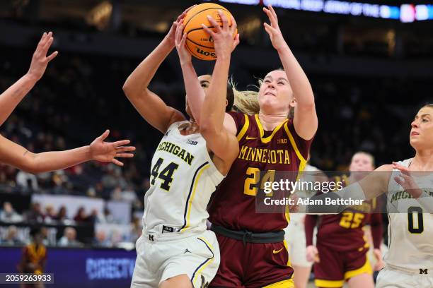 Cameron Williams of the Michigan Wolverines and Mallory Heyer of the Minnesota Golden Gophers battle for a rebound in the Second Round of the Big Ten...