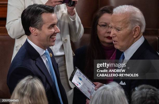 Representative Morgan McGarvey gives a child's drawing of Teddy Roosevelt to US President Joe Biden as he departs at the conclusion of his State of...