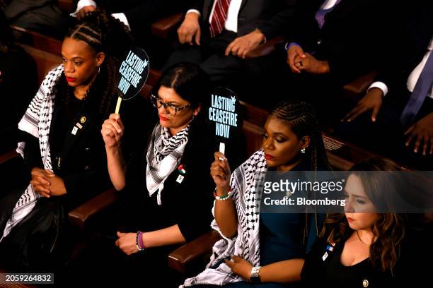 Representative Rashida Tlaib, a Democrat from Michigan, center, and Representative Cori Bush, a Democrat from Missouri, center right, hold up signs...
