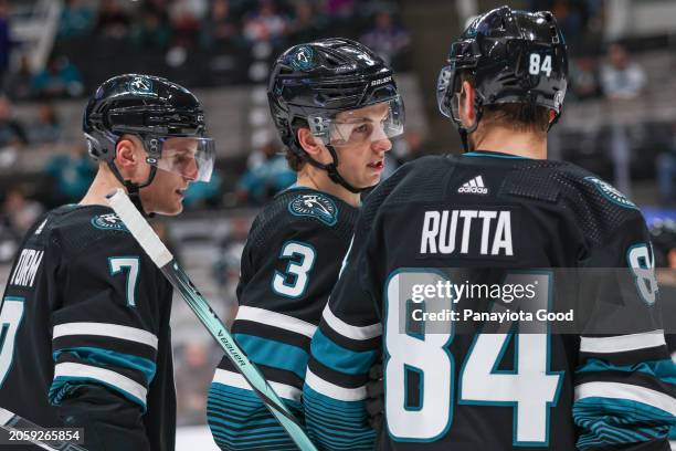 Henry Thrun of the San Jose Sharks talks things over with Jan Rutta during the first period against the New York Islanders at SAP Center on March 7,...