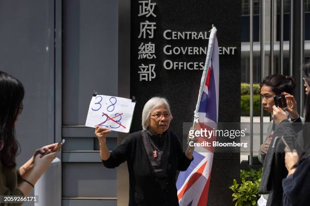 Alexandra Wong, a protester known as Grandma Wong, holds a British Union flag and a sign protesting against Basic Law Article 23 legislation outside...