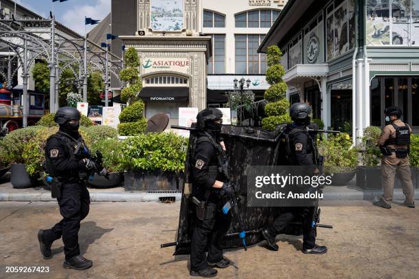 Armed police and bomb squad members are seen walking past the entrance during an active shooter situation at the mall as 500 emergency service...