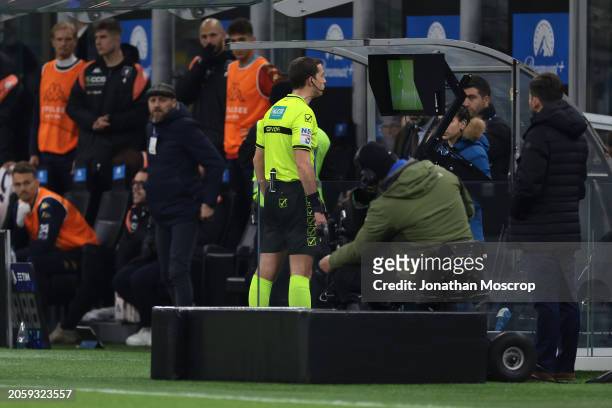 Referee Giovanni Ayroldi observes the VAR monitor prior to awarding FC Internazionale a first half penalty during the Serie A TIM match between FC...