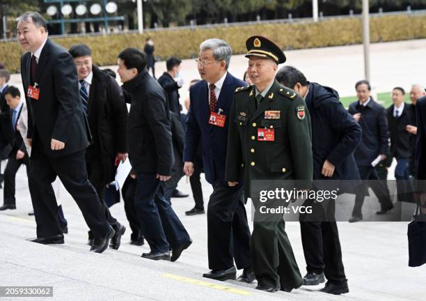 Members of the 14th National Committee of the Chinese People's Political Consultative Conference walk to the Great Hall of the People before the...