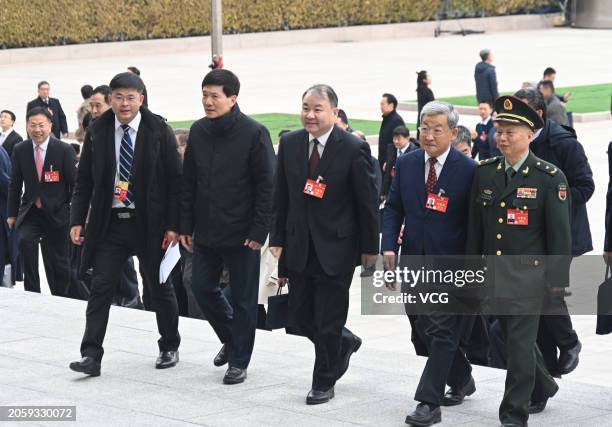 Members of the 14th National Committee of the Chinese People's Political Consultative Conference walk to the Great Hall of the People before the...