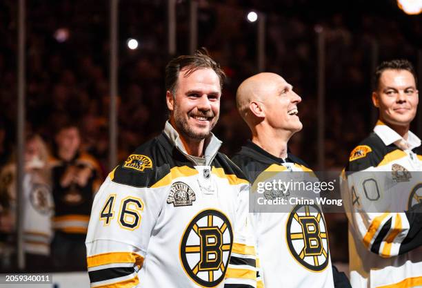 David Krejci and Dennis Seidenberg of the Boston Bruins Patrice smile during a pregame "Return of a Champion Era Night" ceremony before the game...