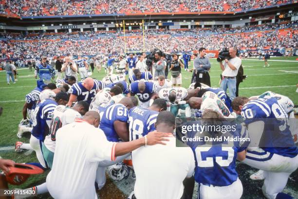 Players from the Indianapolis Colts and the Miami Dolphins kneel as a group following an NFL football game played on December 5, 1999 at Pro Player...