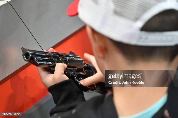 Child holds a BB revolver handgun air pistol during The British Shooting Show at the NEC on February 23, 2024 in Birmingham, England. The show is the...