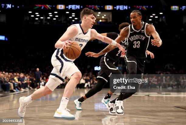 Jake LaRavia of the Memphis Grizzlies heads for the net as Nic Claxton of the Brooklyn Nets defends during the first half at Barclays Center on March...