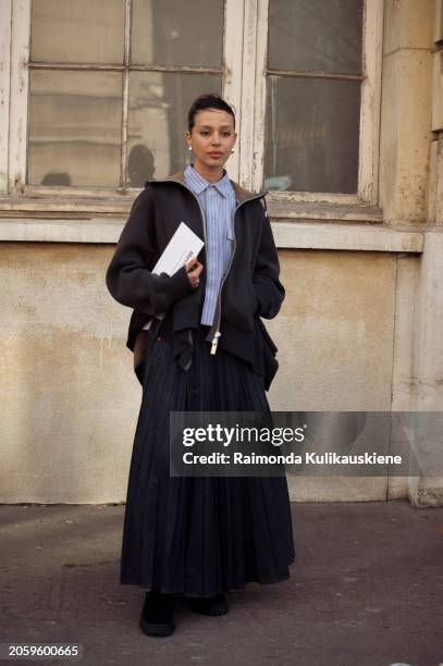 Guest is seen wearing grey zipper hoody, denim skirt, blue button shirt outside Sacai during the Womenswear Fall/Winter 2024/2025 as part of Paris...