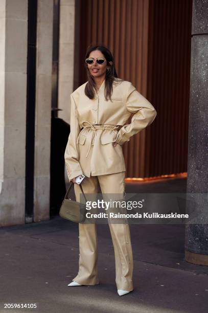 Guest is seen wearing a light creme white or pale yellow leather suit and khaki bag outside Zimmermann during the Womenswear Fall/Winter 2024/2025 as...