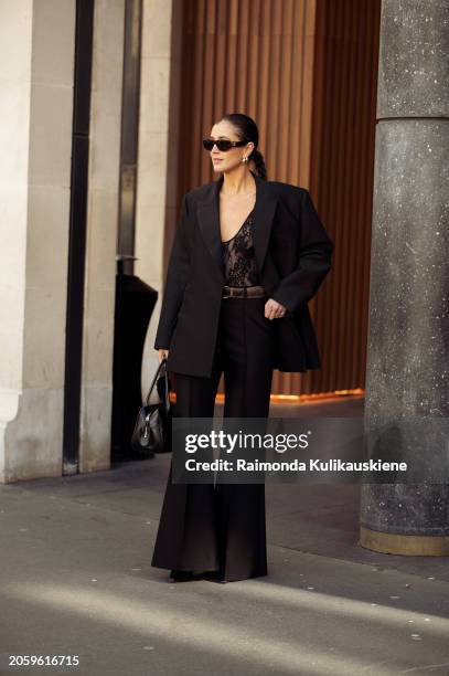 Darja Barannik is seen wearing a black blazer, laced top, flared pants, bag, sunglasses and earrings outside Zimmermann during the Womenswear...