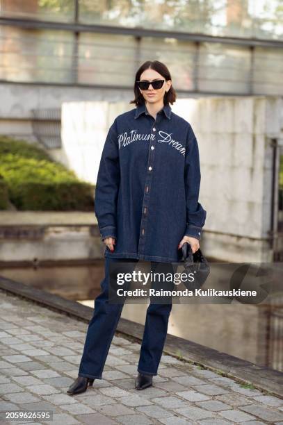 Guest is seen wearing blue jeans, blue shirt with print on the back and black handbag outside Stella McCartney during the Womenswear Fall/Winter...