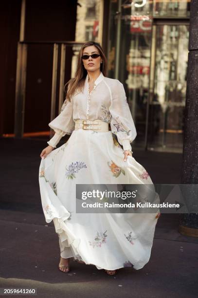 Michelle Salas is seen wearing a white transparent blouse with flower pattern, high waisted skirt or a dress with floral print, a white wide leather...