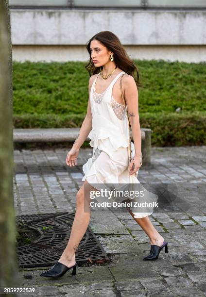 Guest is seen wearing a white layered dress and black heels outside the Stella McCartney show during the Womenswear Fall/Winter 2024/2025 as part of...