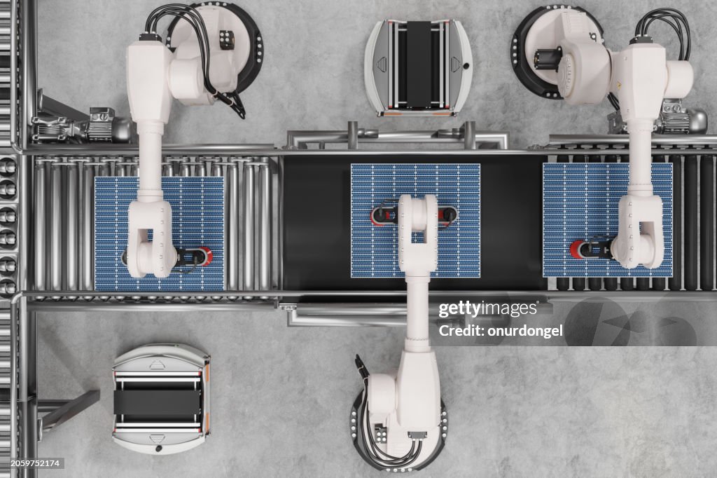 Blick aus der Vogelperspektive auf ein intelligentes Distributionslager mit Roboterarmen, die an der Produktion von Solarmodulen arbeiten