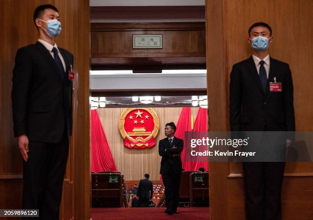 Security stand at the doorway as a delgate walks in the auditorium before the opening of the NPC, or National People's Congress, at the Great Hall of...