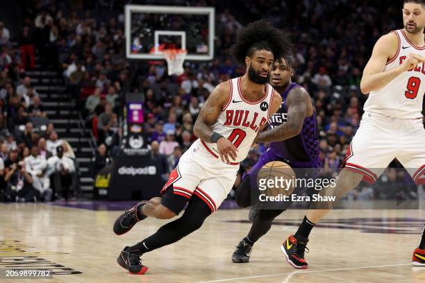 Coby White of the Chicago Bulls is guarded by Davion Mitchell of the Sacramento Kings at Golden 1 Center on March 04, 2024 in Sacramento, California....