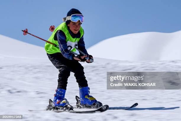 An Afghan skier competes in a ski race on the outskirts of Bamiyan province on March 8, 2024. From the edge of a Bamiyan slope, rivals cheer as they...