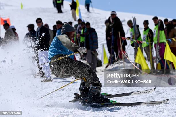 An Afghan skier competes in a ski race on the outskirts of Bamiyan province on March 8, 2024. From the edge of a Bamiyan slope, rivals cheer as they...