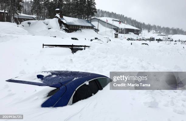 Vehicles are covered in snow at Boreal Mountain Resort, currently shuttered due to the storm, following a massive snowstorm in the Sierra Nevada...