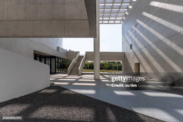 sunshine leaves light and shadow on cement walls and structures in modern architecture - cimento imagens e fotografias de stock
