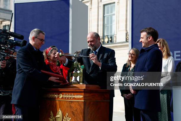 French President Emmanuel Macron and Justice Minister Eric Dupond-Moretti take part in a ceremony to seal the right to abortion in the French...