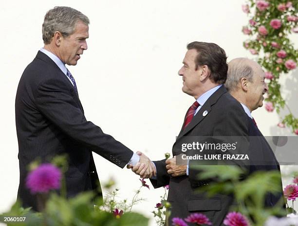 President George W. Bush and German Chancellor Gerhard Schroeder shake hands as Greek President Konstantinos Simitis walks by, before the G8 Leaders...