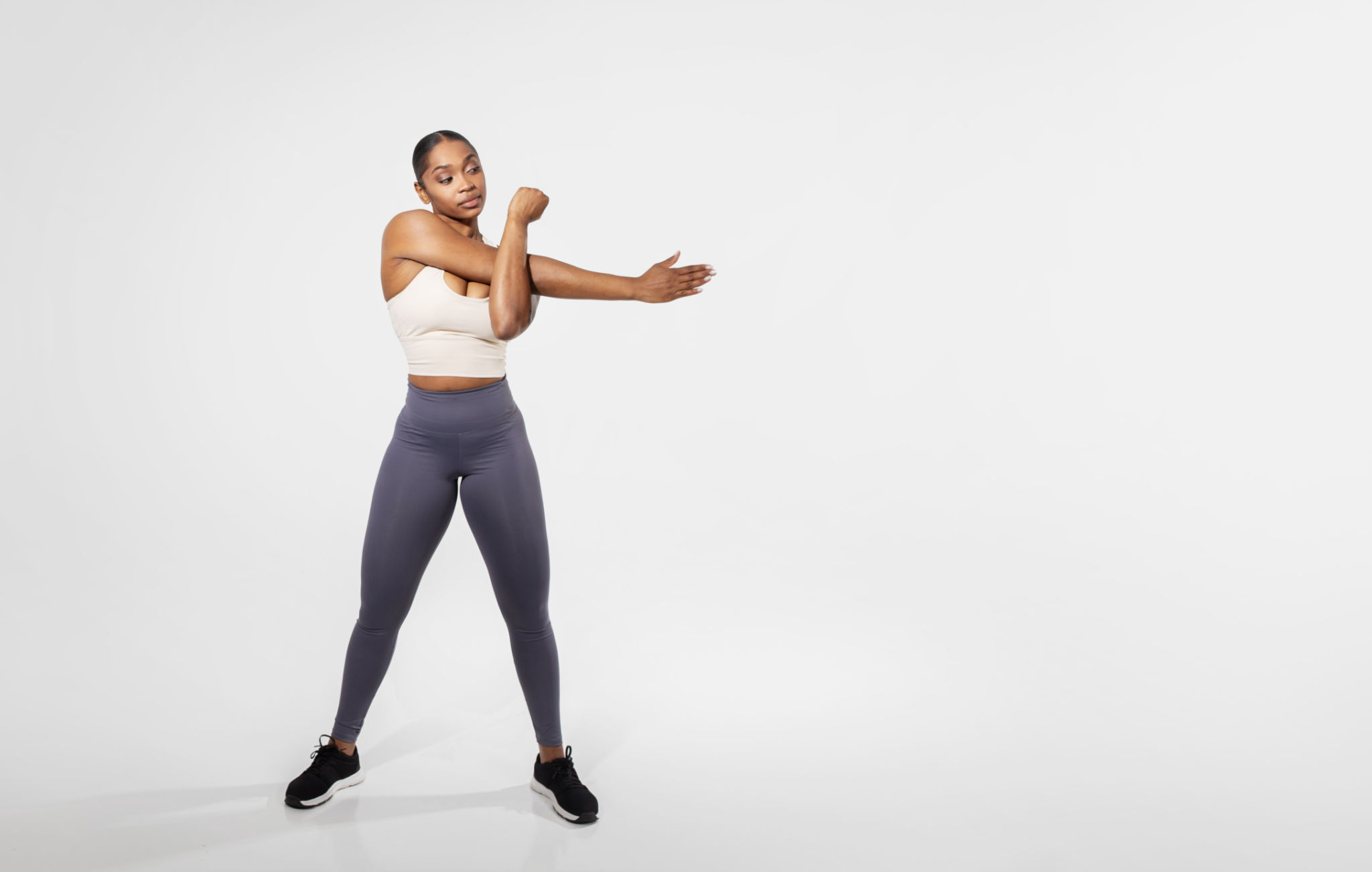 Full length of black fitness woman stretching arms training, studio Full length of black fitness woman stretching arms training, studio