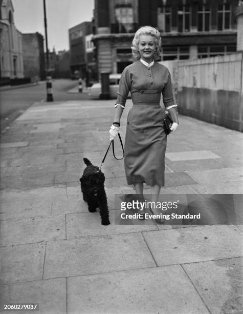 Canadian actress Shirley Douglas walking a small black dog, September 2nd 1955.