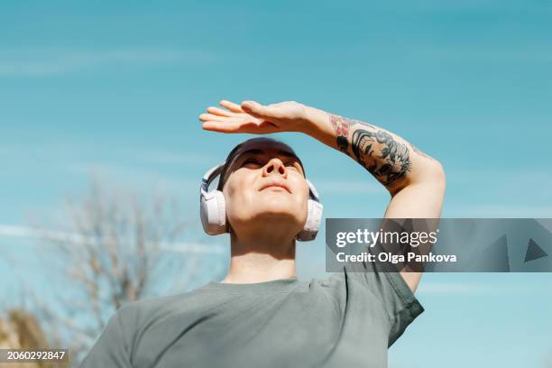 woman shielding eyes from sun with her hand - aquamarine eyes stock pictures, royalty-free photos & images