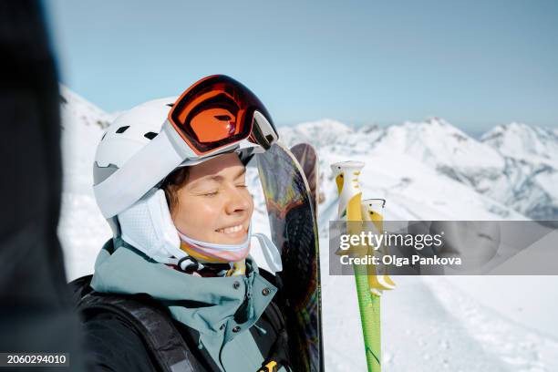 middle-aged woman takes a self-portrait, selfie while alpine skiing in the mountains. - ski stockfoto's en -beelden