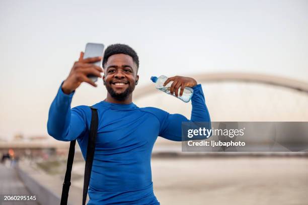 active african male person smile and flexing for sports photograph. - flexing bicep stock pictures, royalty-free photos & images