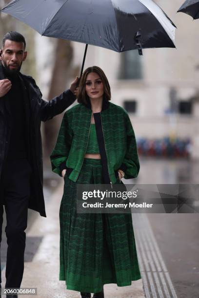 Olivia Palermo seen wearing a green oversized pattern bomber jacket, matching green pattern crop top, matching green pattern pleated midi skirt and...