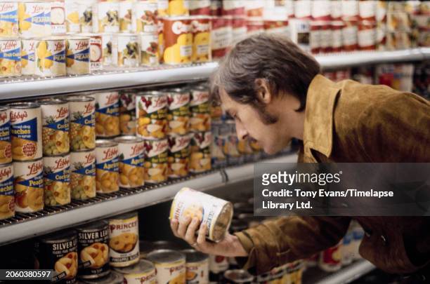 American artist Ed Ruscha shopping for organic produce for his edition of prints of "News, Mews, Pews, Brews, Stews, Dues" at a supermarket, London,...