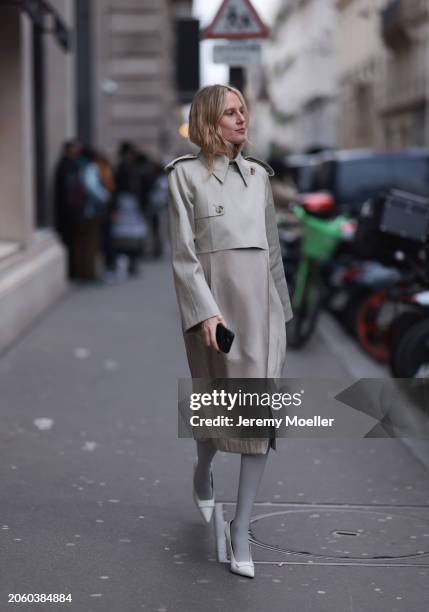 Elly McGaw seen wearing beige midi long coat, grey tights and white shiny leather heels / pumps, outside Vetements, during the Womenswear Fall/Winter...