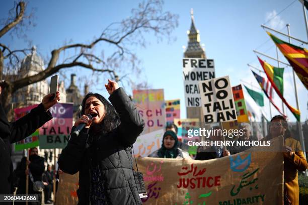 Protesters hold placards at a demonstration calling for women's rights in Afghanistan, in Parliament Square in London on March 8 on International...