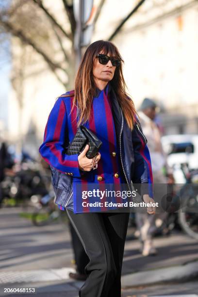 Caroline de Maigret wears a red and blue striped military jacket with golden buttons, a Chanel bag, black flared pants, outside Sacai, during the...