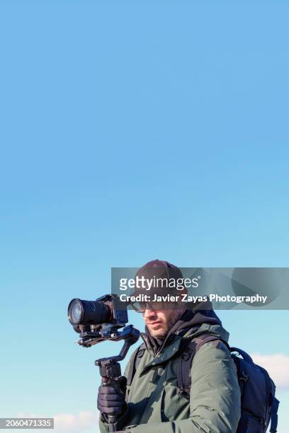 videographer operating camera outdoors - camera operator stock pictures, royalty-free photos & images