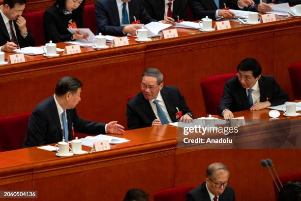 Chinese President Xi Jinping speaks with Chinese Premier Li Qiang and Chairman of the Chinese People's Political Consultative Conference Wang Huning...