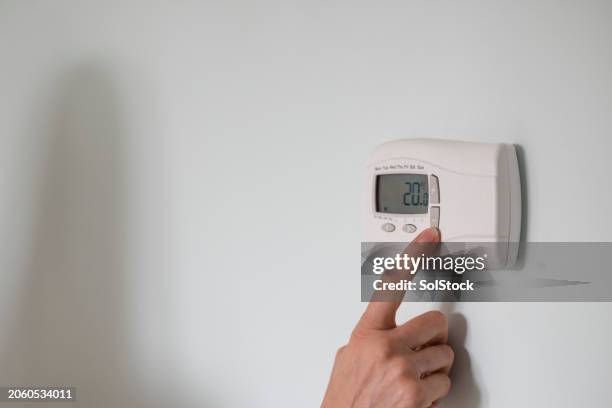 saving energy at home - thermostat stock pictures, royalty-free photos & images